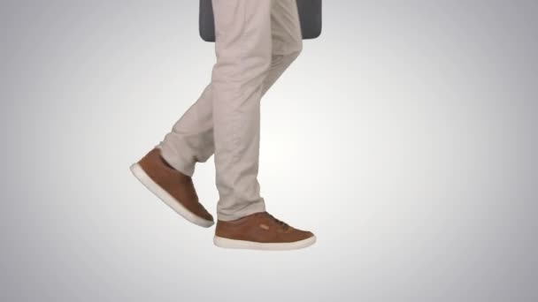Манские ноги ходят в джинсах и кедах на заднем плане . — стоковое видео