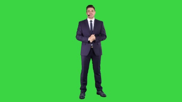 Homem em roupa formal com um fone de ouvido apresentando algo em uma tela verde, Chroma Key . — Vídeo de Stock