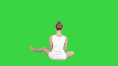 Güzel genç kadın spor giyen yoga lotus oturan yeşil ekranda poz, Chroma Key.