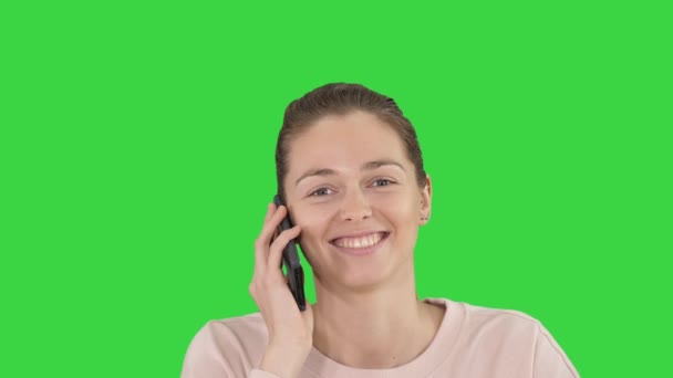Sonriendo hermosa joven mujer haciendo una llamada mirando a la cámara en una pantalla verde, Clave de croma . — Vídeo de stock