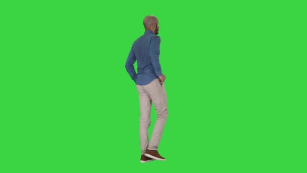 Lässiger junger Mann, der auf einem grünen Bildschirm läuft, Chroma-Taste. — Stockvideo