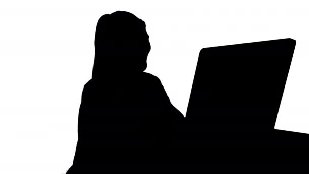 Silhouette Donna felice che fa una videochiamata seduta davanti al suo computer. — Video Stock