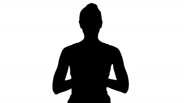 Силуэт Молодая женщина йога практикует йогу, делает жест намасте, тренируется, носит белую футболку . — стоковое видео