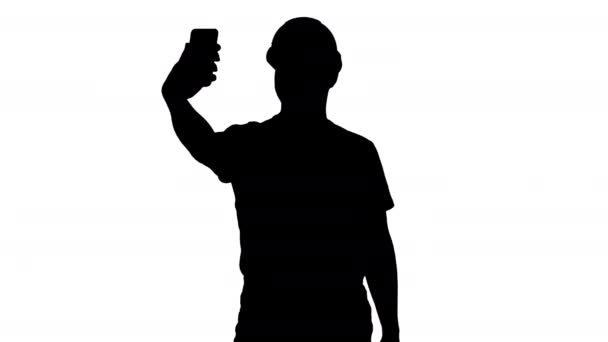 Silhouette Smiling joven constructor guapo haciendo selfie con teléfono móvil . — Vídeos de Stock