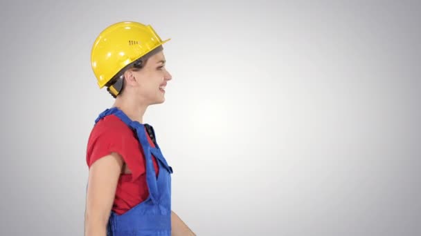 활달 한 모자를 쓰고 걸어오는 여성 노동자 행복 한 건축 및 경사있는 배경에 대한 건축 개념. — 비디오