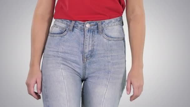 グラデーションの背景に高いジーンズと赤いTシャツで歩くカジュアルな女性. — ストック動画