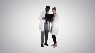 Ciddi iyi kadın doktor ve afro-amerikalı doktor. Gradyan arka planda beyin röntgeni inceleniyor..