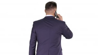 Beyaz arka planda cep telefonuyla konuşan yürüyen bir iş adamı..