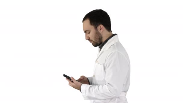 Retrato de primer plano del guapo profesional de la salud masculino o médico o enfermero, mensajes de texto en el teléfono celular sobre fondo blanco . — Vídeos de Stock