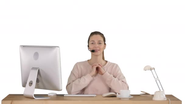 Mujer joven feliz en auriculares mirando a la cámara y hablando sobre fondo blanco. — Vídeos de Stock