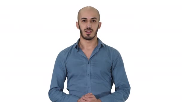 Αραβικό νεαρό άντρα με πουκάμισο μιλάει παρουσιάζοντας κάτι και δείχνοντας το πλάι σε λευκό φόντο. — Αρχείο Βίντεο