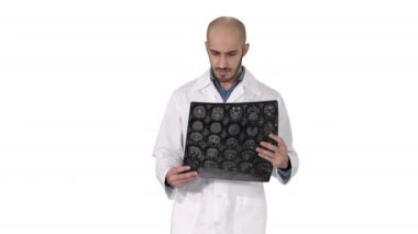 Arap hekim beyaz arka planda yürürken MRI beyin taramasını inceliyor.