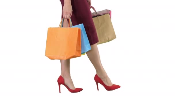 Piernas de la señora de las compras con bolsas de compras sobre fondo blanco. — Vídeo de stock