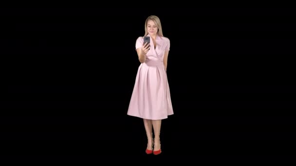 Mujer rubia en ropa rosa tomando selfie y caminando, Alpha Channel — Vídeo de stock