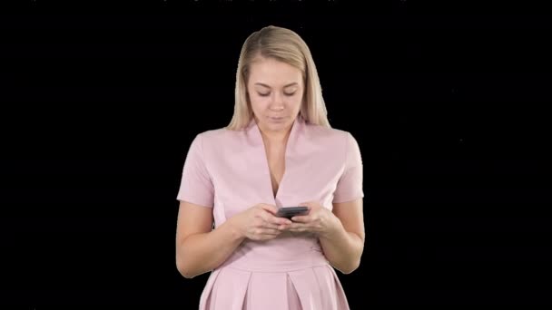 Портрет улыбающейся юной леди, читающей текстовое сообщение на мобильном телефоне Альфа-канал — стоковое видео