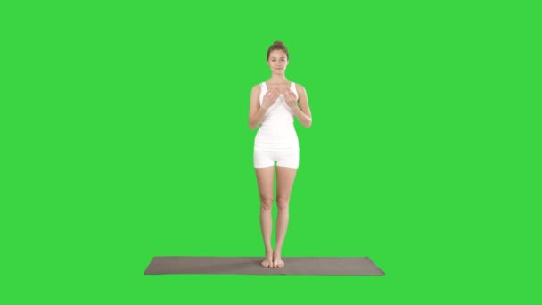 Красивая спортивная молодая женщина в белой спортивной одежде, занимающаяся идолопоклонничеством Утттхита Хаста Падангустасана, с протянутой рукой до большого пальца на зелёном экране, хрома-ключ . — стоковое видео