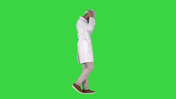 Medico arabo che cammina e mette il cappuccio medico su uno schermo verde, chiave del cromo . — Video Stock