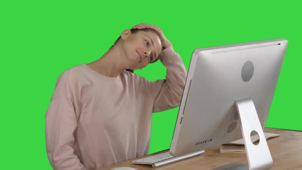 Uitgeput jonge vrouw zitten thuiskantoor Bureau masseren nek op een groen scherm, Chroma Key. — Stockvideo