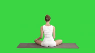 Sakin güzel kadın Yoga egzersiz oturma yaparken Yoga poz yeşil ekran, Chroma anahtar.