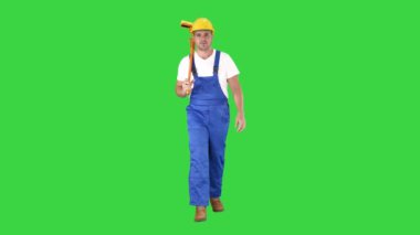 Housecleaner kask bir yeşil ekran üzerinde bir paspas ile yürüyüş, Chroma anahtar.