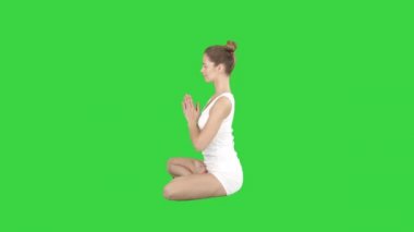 Genç beyaz sarışın kadın uygulama yoga üzerinde bir yeşil ekran, Chroma anahtar.