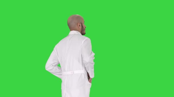 Walking läkare i en mantel på en grön skärm, Chroma Key. — Stockvideo