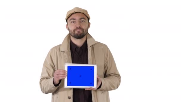 Homem na trincheira andando e segurando tablet com tela azul mockup apresentando algo no fundo branco. — Vídeo de Stock