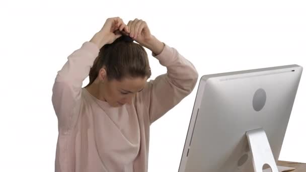 Office Lady in roze pullover met een Pony staart haar werken op de computer op witte achtergrond. — Stockvideo