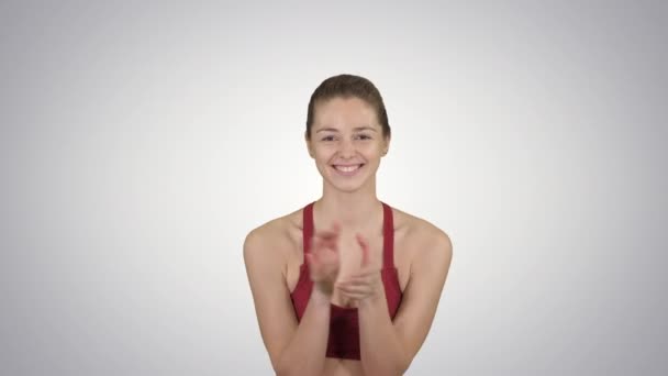 Όμορφη νεαρή γυναίκα χειροκροτεί και χαμογελά στο φόντο ντεγκραντέ. — Αρχείο Βίντεο