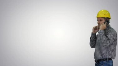 Gradyan arka planda akıllı telefon kullanan inşaat işçisi.