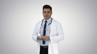 Klinisyen Doktor adam gösteren Ilaçlar Ilaç ve degrade arka planda kamera konuşmak.