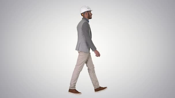 Architect in white helmet walking on gradient background. — Stock Video