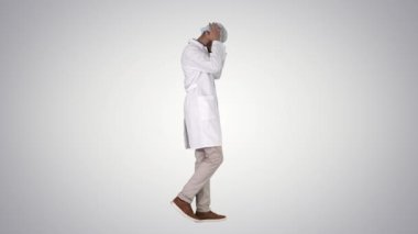 Arap Doktor yürüyüş ve degrade arka planda tıbbi kap koyarak.