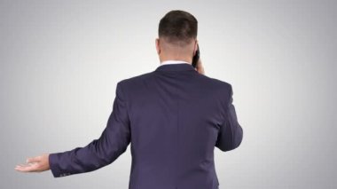 Akıllı telefonlu bir iş adamı, gradyan arka planda bir telefon görüşmesi yapıyor..