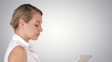 Tek başına yürüyen ve medya içeriğini tablet Alfa Kanalı 'nda seyreden bir kız.