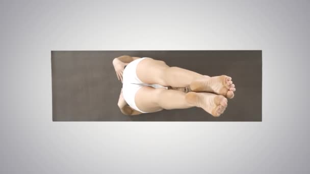 Mujer practicando yoga, de pie en el ejercicio de salamba sarvangasana, apoyada pose de hombro sobre fondo degradado . — Vídeo de stock