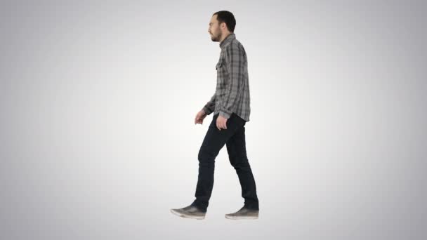 Jonge casual man lopen op gradiënt achtergrond. — Stockvideo
