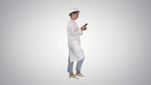 Wissenschaftlerin nutzt Smartphone beim Gehen auf Steigungshintergrund. — Stockvideo