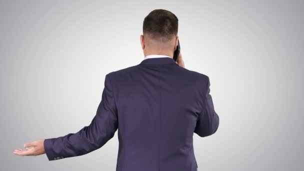 Empresário com smartphone, fazendo um telefonema no fundo gradiente. — Vídeo de Stock