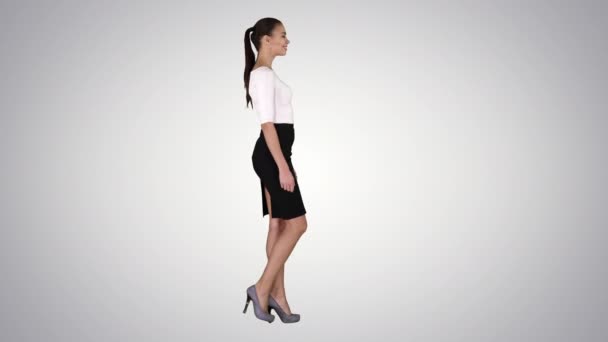 Jovem mulher de negócios está andando sobre fundo gradiente. — Vídeo de Stock
