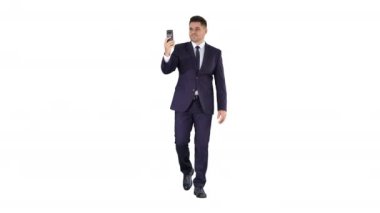 Genç işadamı beyaz arka planda yürürken iş ortağına telefon etmek için akıllı telefon kullanıyor..