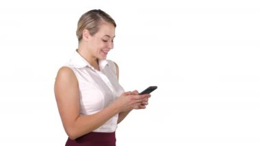 Akıllı telefonu tutan çekici genç bir kadına mesaj atmak ve beyaz arka planda dururken gülümseyerek ona bakmak..