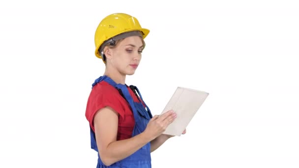 Female construction engineer looking at tablet and checking object on white background. — Stock Video