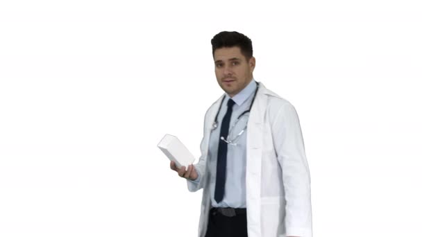 Pewny siebie lekarz uśmiecha się i prezentuje w dłoni Nowe leczenie na białym tle. — Wideo stockowe