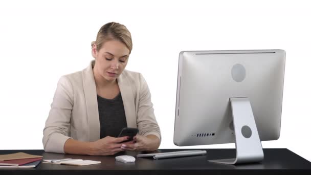 Frau benutzt Handy am Schreibtisch, weißer Hintergrund — Stockvideo