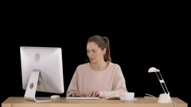 Kulaklık takan güzel, genç bir kadın. Alpha Channel 'da çalışıyor.