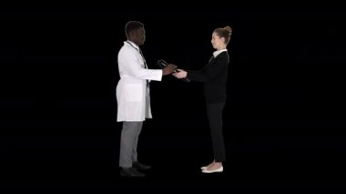 Hasta X ışını ile doktora geliyor. Fizyoterapist hastaya röntgeni açıklıyor. Alfa Kanalı.