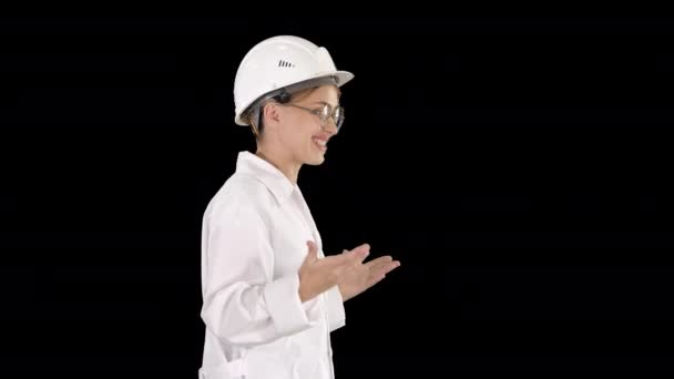 Jeune scientifique en blouse de laboratoire et casque de sécurité marchant et disant quelque chose, Canal Alpha — Video