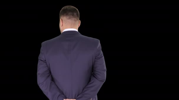 Uomo d'affari che cammina e si guarda intorno tenendosi per mano dietro la schiena, Alpha Channel — Video Stock