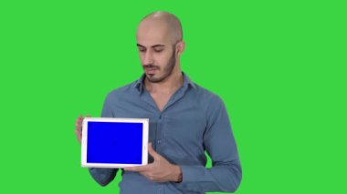Yeşil Ekranda boş tablet ekranı gösteren Arap adam, Chroma Key.